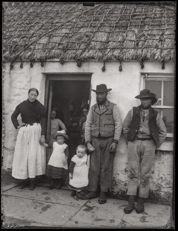 Andrew Francis Dixon took this photo in the Aran Islands in 1890 in the company of Alfred Cort Haddon. A family group are gathered at the doorway of a cottage, below a neatly netted thatch roof. They wear thein traditional dress of islanders. Photo credit: A. F. Dixon. 1890. Untitled. Digital print of silver gelatine, glass-plate negative (Ciarán Walsh and Ciarán Rooney, 2019 © curator.ie). The original negative is held in the School of Medicine, Trinity College, University of Dublin. Alt text: Ciarán  Walsh, curator.ie.